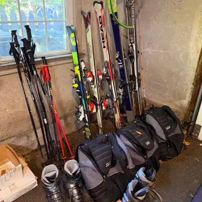 Sale Photo Thumbnail #229: Collection of modern ski gear, including downhill skis by Head, Rossignol, and Völkl, paired with ski boots, poles, and Swix gear bags.
