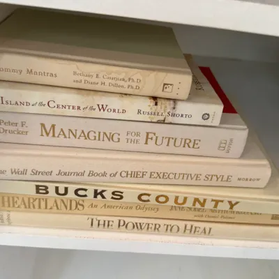 Sale Photo Thumbnail #144: Stack of assorted hardcover and paperback non-fiction books resting on a white shelf.