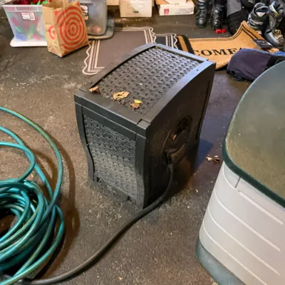 Sale Photo Thumbnail #216: Black plastic wicker-style garden hose reel box with side crank handle, shown with a green garden hose attached.