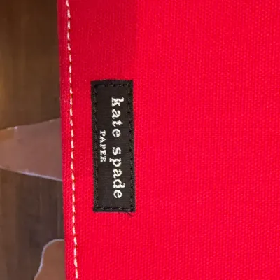 Sale Photo Thumbnail #174: Kate Spade Paper red canvas item featuring stitched white detail and a black embroidered label.