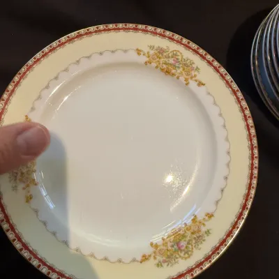Sale Photo Thumbnail #191: Vintage porcelain china bread or salad plate featuring a cream center, gold-tone floral sprays, and a red patterned outer rim.