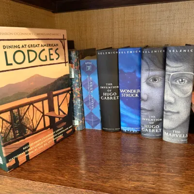 Sale Photo Thumbnail #247: Collection of hardcover books including Brian Selznick illustrated novels, a Harry Potter book, and Dining at Great American Lodges.