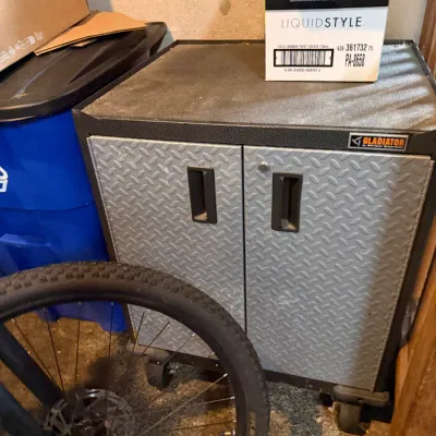 Sale Photo Thumbnail #234: Gladiator metal rolling storage cabinet featuring silver diamond plate doors and black recessed handles.