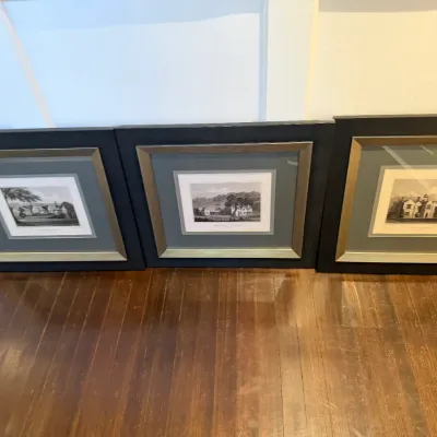 Set of three framed architectural landscape prints with double matting in matching metallic and black frames.