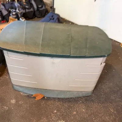Sale Photo Thumbnail #215: Large outdoor plastic resin storage deck box with a dark green lid and off-white body.