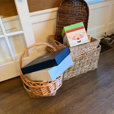 Sale Photo Thumbnail #175: Collection of woven storage baskets and decorative gift boxes arranged on a hardwood floor near an interior doorway.