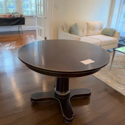 Sale Photo Thumbnail #127: Dark wood round pedestal dining table featuring metallic trim around the top edge and pedestal base.