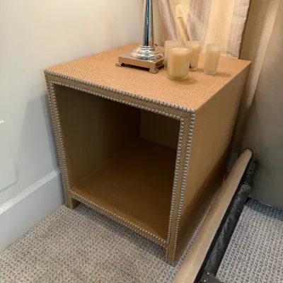 Contemporary woven fabric cube nightstand featuring nailhead trim details around the front opening.