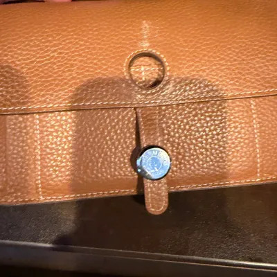 Hermès Dogon long wallet in cognac textured leather, featuring silver-tone Clou de Selle snap closure and cream contrast stitching.