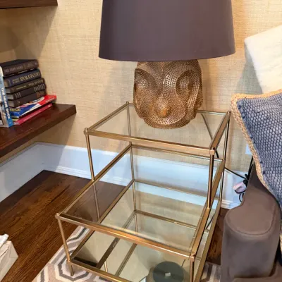 Sale Photo Thumbnail #209: Modern brass-tone multi-tiered glass side table featuring a contemporary textured gold table lamp with a dark shade.