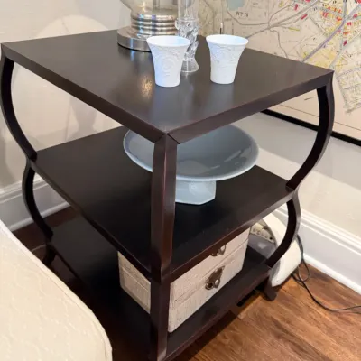 Sale Photo Thumbnail #113: Dark espresso-stained wood three-tier side table featuring curved, cabriole-style legs, displaying decorative porcelain and glass pieces.