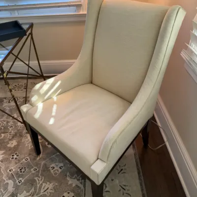 Sale Photo Thumbnail #169: Contemporary high-back armchair upholstered in cream fabric, featuring dark wood legs.