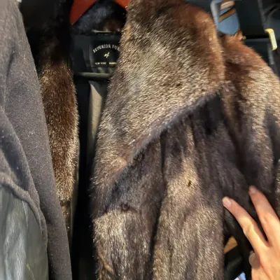 Vintage dark brown mink fur coat by Superior Furs of New York with a wide collar, hanging on a wooden hanger.