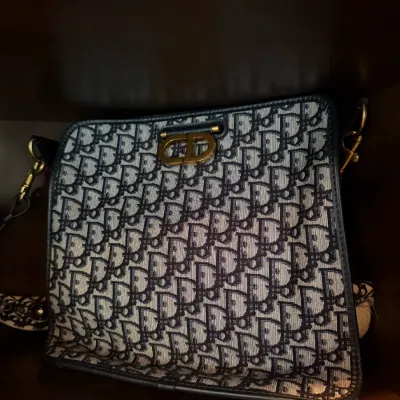 Christian Dior Oblique canvas shoulder bag featuring navy monogram print and antique gold-tone CD clasp hardware.