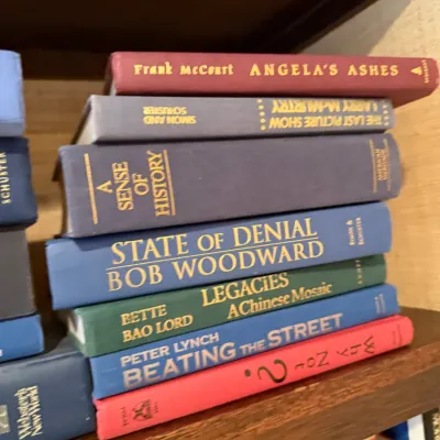 Sale Photo Thumbnail #253: Stack of hardcover non-fiction and fiction books, including works by Frank McCourt, Bob Woodward, and Peter Lynch, on a wooden bookshelf.