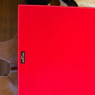 Sale Photo Thumbnail #173: Kate Spade red desk blotter with white accent stitching and a black logo tag.