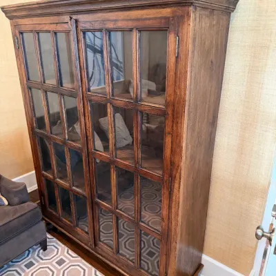 Sale Photo Thumbnail #207: Rustic wood cabinet featuring two multi-pane glass doors and interior shelving.