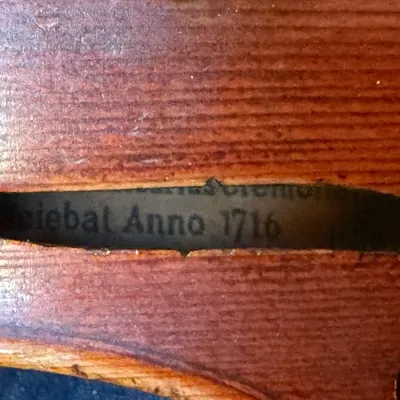 Interior maker's label visible through the f-hole of a violin, dated 1716.