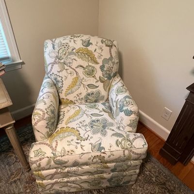Sale Photo Thumbnail #8: Upholstered armchair featuring a floral and jacobean pattern in muted green, blue, and yellow tones on an off-white background.