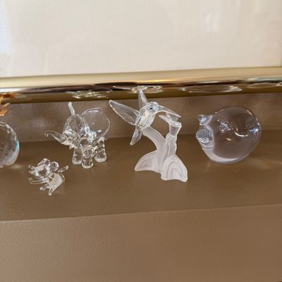 Collection of small clear and frosted crystal animal figurines, including a hummingbird, elephant, mouse, and pig.