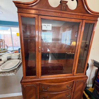 Vintage mahogany china cabinet hutch featuring a broken-arch bonnet top pediment, glass-paneled display doors, and a serpentine-front...