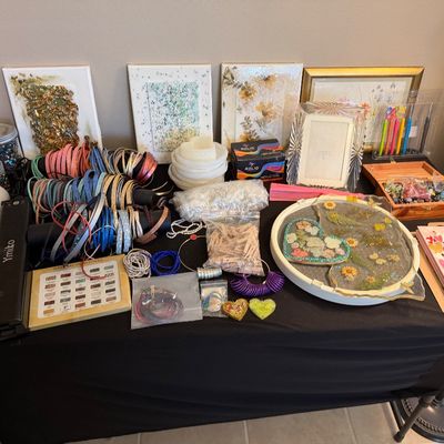 Large collection of crafting and jewelry-making supplies, including colorful cording, resin art trays, beads, silicone molds, and framed...