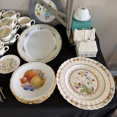 Collection of vintage ceramics and tableware, including Spode dishes, fruit motif plates, decorative ceramic houses, and teacups arranged...