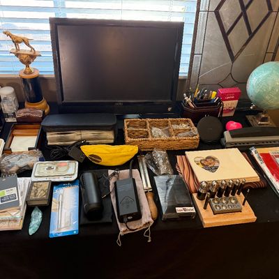 Collection of tabletop items including a Vizio monitor, a globe, dog trophy, crafting tools, desk organizers, and assorted office supplies.