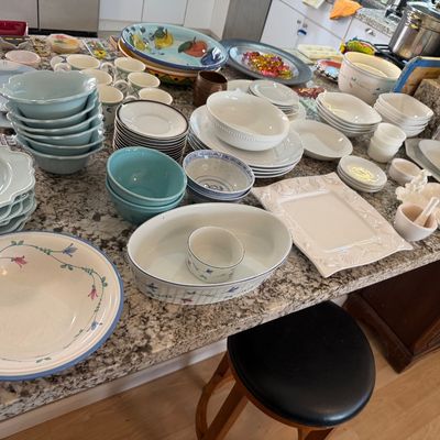 Large collection of ceramic and porcelain kitchenware, featuring light blue scalloped dinnerware, floral-patterned serving bowls,...