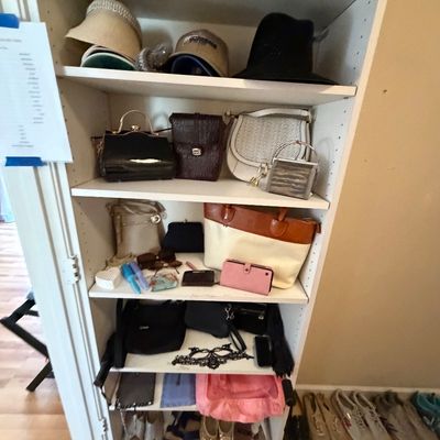 White shelving unit filled with a variety of women's hats, handbags, small accessories, and shoes.