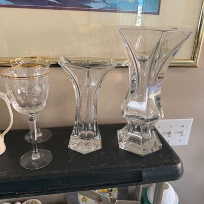 Collection of clear glassware, including two heavy faceted cut crystal vases and gold-rimmed stemmed wine glasses.