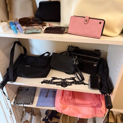 Collection of women's accessories displayed on shelves, including leather handbags, clutch purses, wallets, sunglasses, shoes, and...