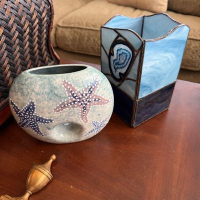 Hand-painted ceramic vase with starfish motifs alongside a blue stained-glass vase featuring a agate slice inlay.