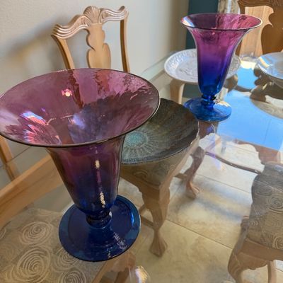 Pair of flared purple-to-blue ombre glass vases displayed on a glass-top dining table.
