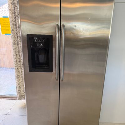 Modern GE stainless steel side-by-side refrigerator featuring an in-door water and ice dispenser.