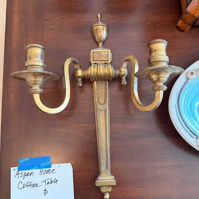 Vintage French Neoclassical-style gilt brass two-arm wall sconce featuring an urn finial and tapered backplate.
