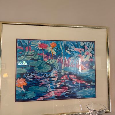 Framed watercolor art print depicting koi fish swimming in a water lily pond, set in a gold-tone metal frame with double matting.