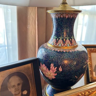 Sale Photo Thumbnail #11: Vintage Chinese cloisonné table lamp with floral motifs in blue and pink enamels, mounted on a wooden base next to framed antique portraits.