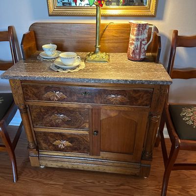 Sale Photo Thumbnail #14: Antique marble-top washstand featuring carved burled wood drawer fronts, displayed with teapot and teacups.