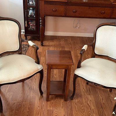 Sale Photo Thumbnail #56: Pair of French Provincial style upholstered armchairs with carved dark wood frames, paired with a small wooden side table.