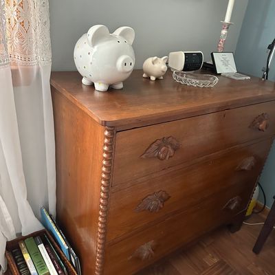 Sale Photo Thumbnail #28: Antique wooden three-drawer chest featuring carved leaf handles and beaded trim along the corners, displayed with small decor items on top.