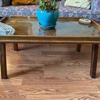 Sale Photo Thumbnail #121: Mid-century wooden coffee table with a glass insert top and raised gallery edge, showing some surface wear.