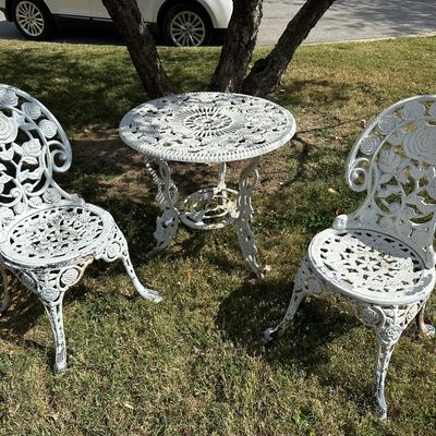 Sale Photo Thumbnail #130: Vintage white cast iron three-piece bistro set featuring ornate rose and floral motifs with light paint wear.