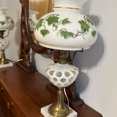 Sale Photo Thumbnail #89: Vintage hurricane-style table lamp featuring a hand-painted green ivy shade, coin dot milk glass body, and brass stem on a square marble base.