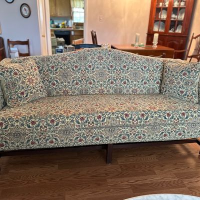 Sale Photo Thumbnail #45: Traditional camelback sofa upholstered in a floral tapestry fabric, accompanied by two matching throw pillows.