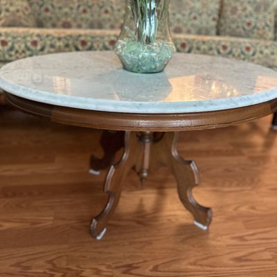 Sale Photo Thumbnail #44: Round white marble-topped coffee table featuring a carved wood pedestal base with curved legs.