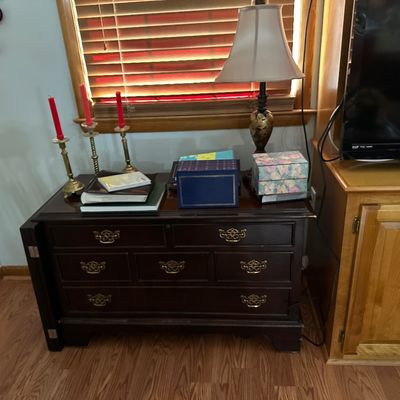 Sale Photo Thumbnail #18: Traditional dark wood low Lane cedar chest  with ornate brass hardware, topped with decorative items including brass candlesticks and a table lamp.