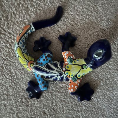 Sale Photo Thumbnail #34: Hand-painted Mexican Talavera pottery gecko figurine with vibrant floral and geometric designs, shown in good condition.
