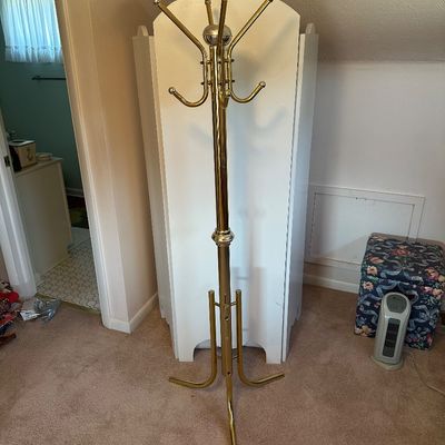 Sale Photo Thumbnail #149: Vintage brass-toned metal coat rack with multiple hooks and a tripod base.