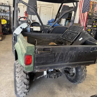 Sale Photo Thumbnail #99: Yamaha utility terrain vehicle (UTV) with a green body, black roll cage, hardtop roof, and rear cargo bed.